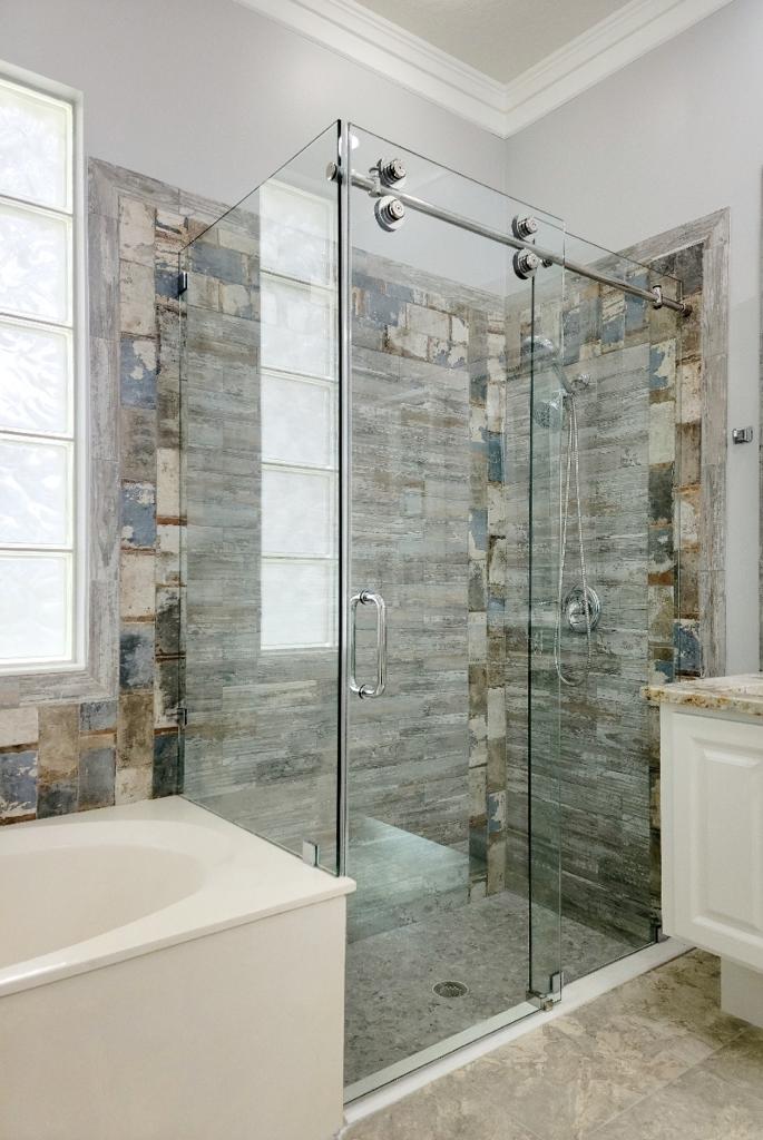 Frameless corner shower enclosure with sliding glass door